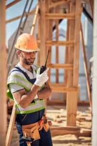 Attentive builder being in all ears while listening to his colleague on the construction site